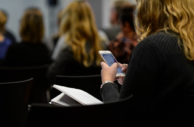 girl using an app at a conference, instead of wasteful printed materials