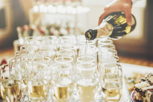 Man pouring champagne into white glasses