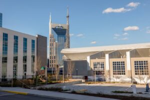 Skyline view featuring Nashville's iconic AT&T Building, modern architecture under blue skies.
