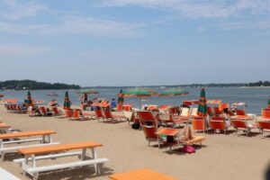 Sunny day at the beach on Shelter Island with chairs and umbrellas by the ocean.