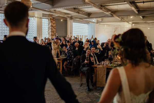 Wedding couple facing their guests cheering